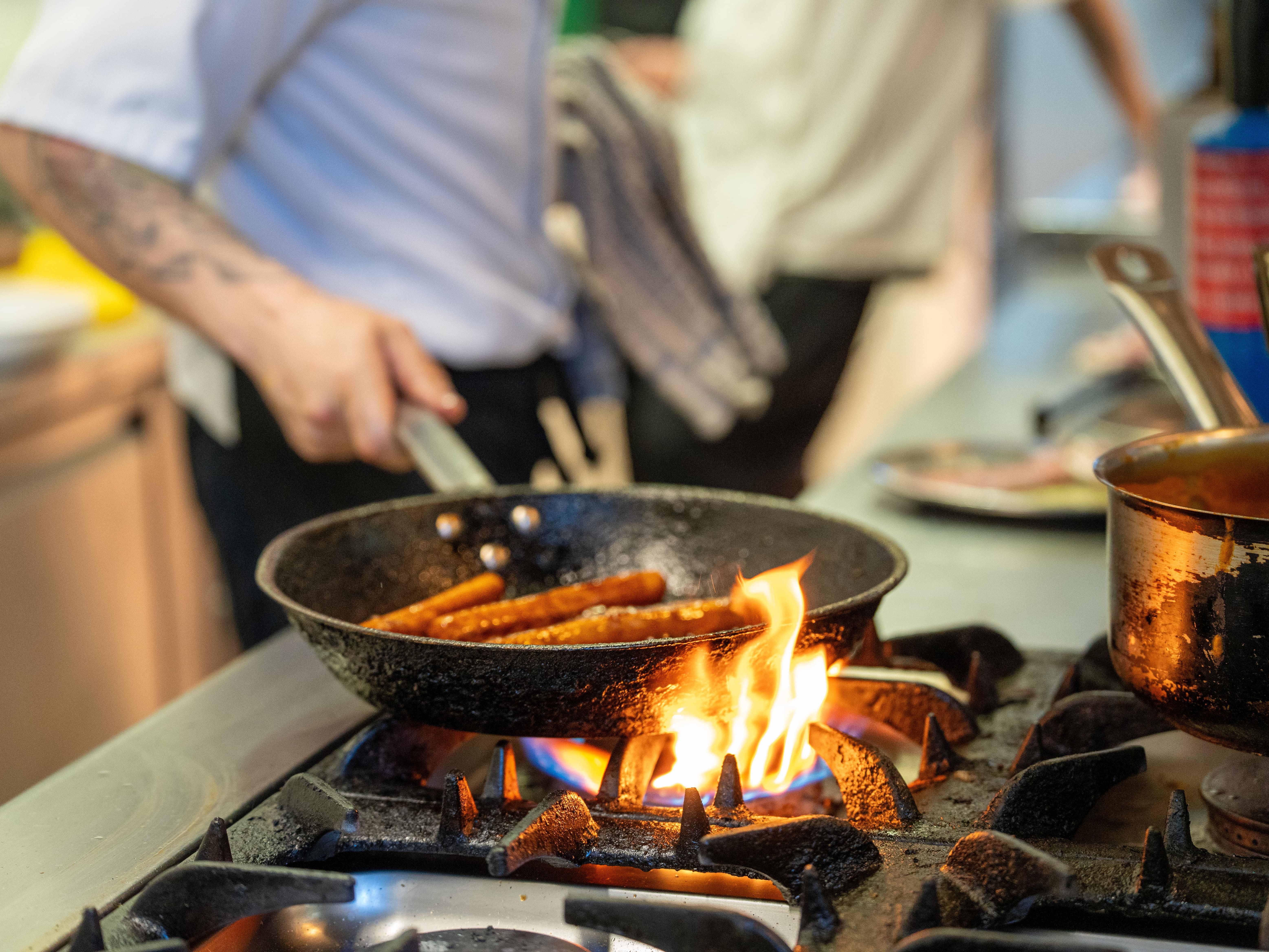 Chef frying food on flaming grill