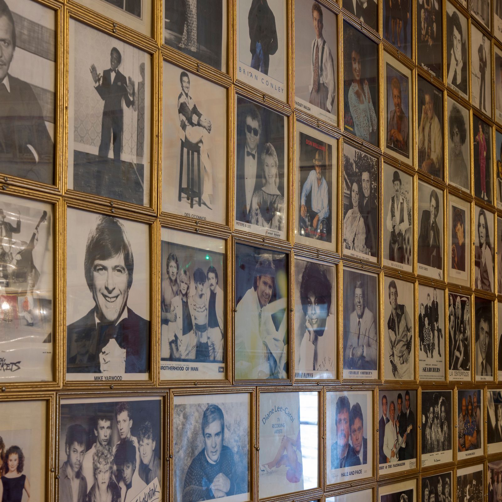 A wall covered with framed photographs of various entertainers and celebrities.