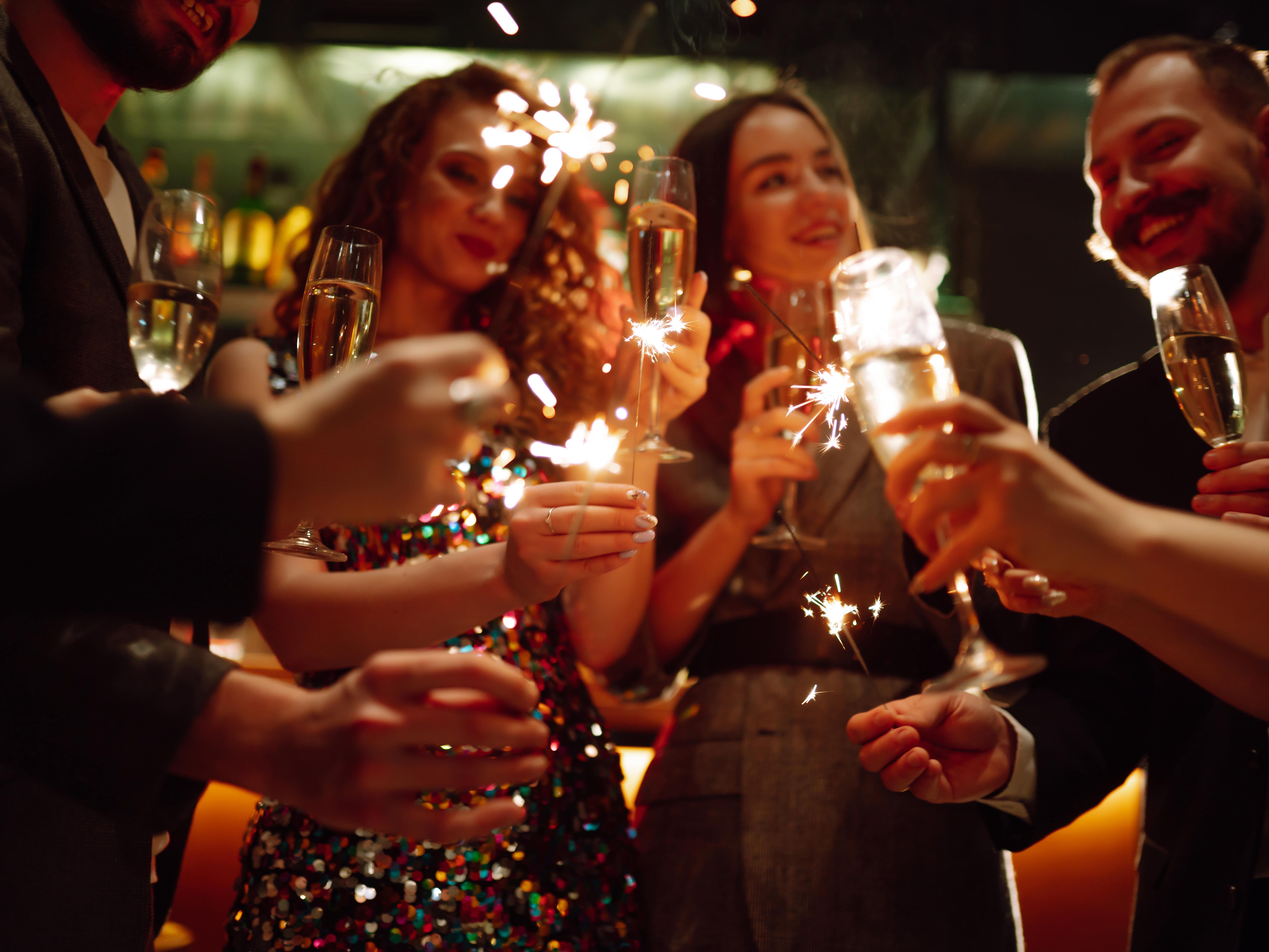 Group of people celebrating with sparklers and champagne glasses