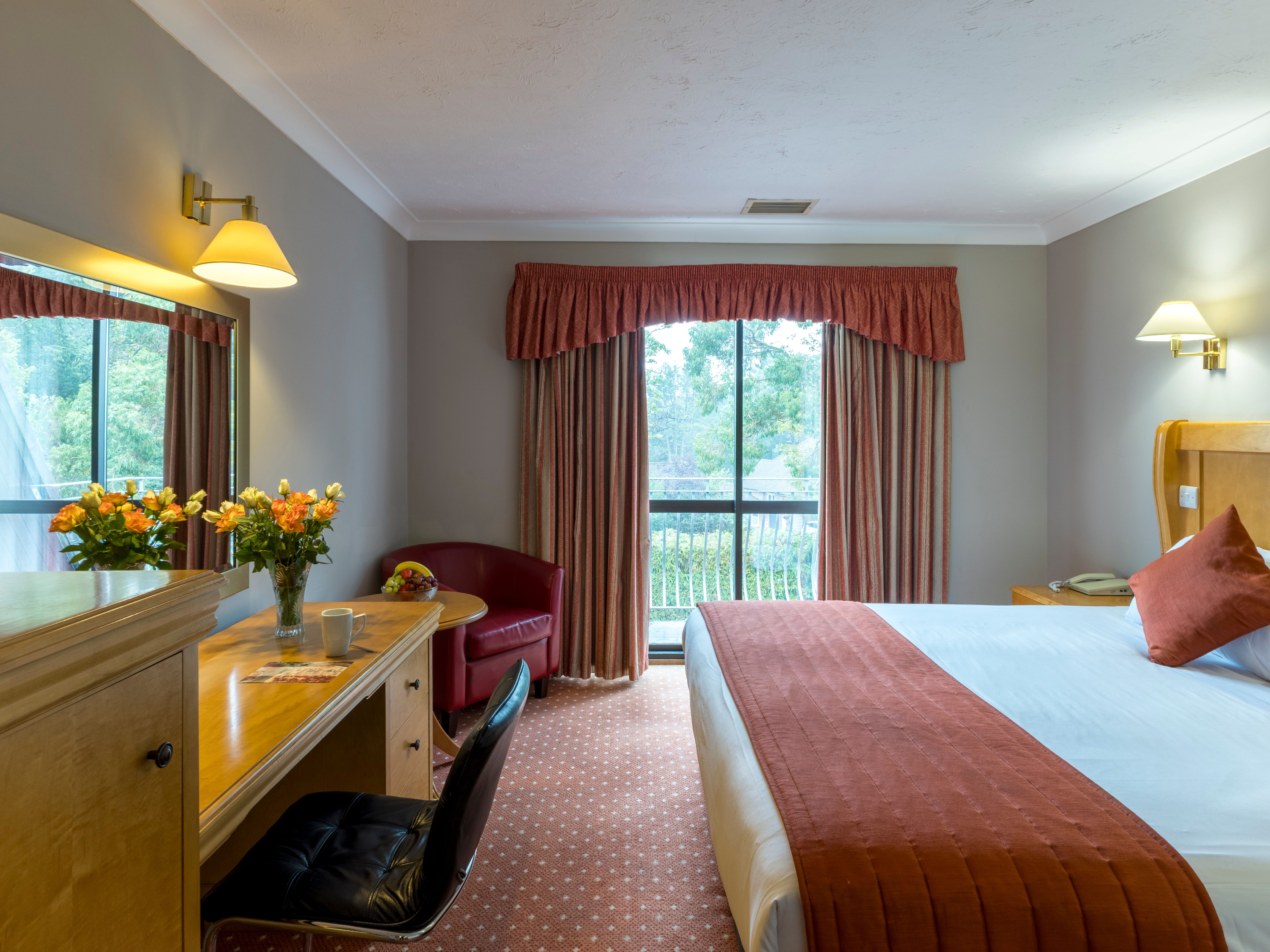 Hotel room with double bed, desk, and window with curtains