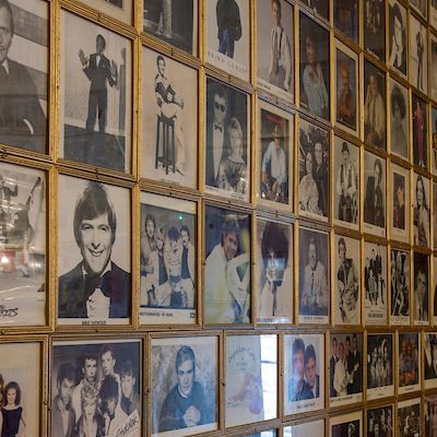 A wall filled with framed autographed celebrity photographs.