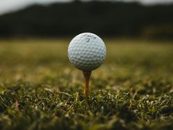 Close-up of a golf ball on a tee in the grass