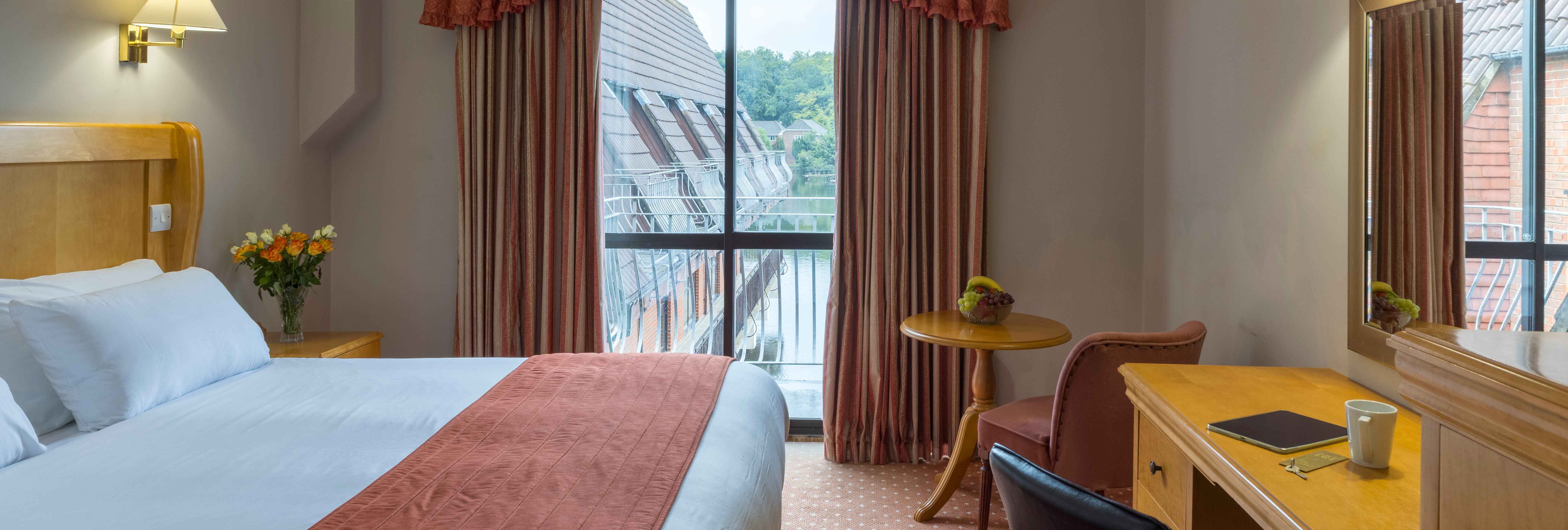 Cozy hotel room with a large bed, desk, and window with a view.