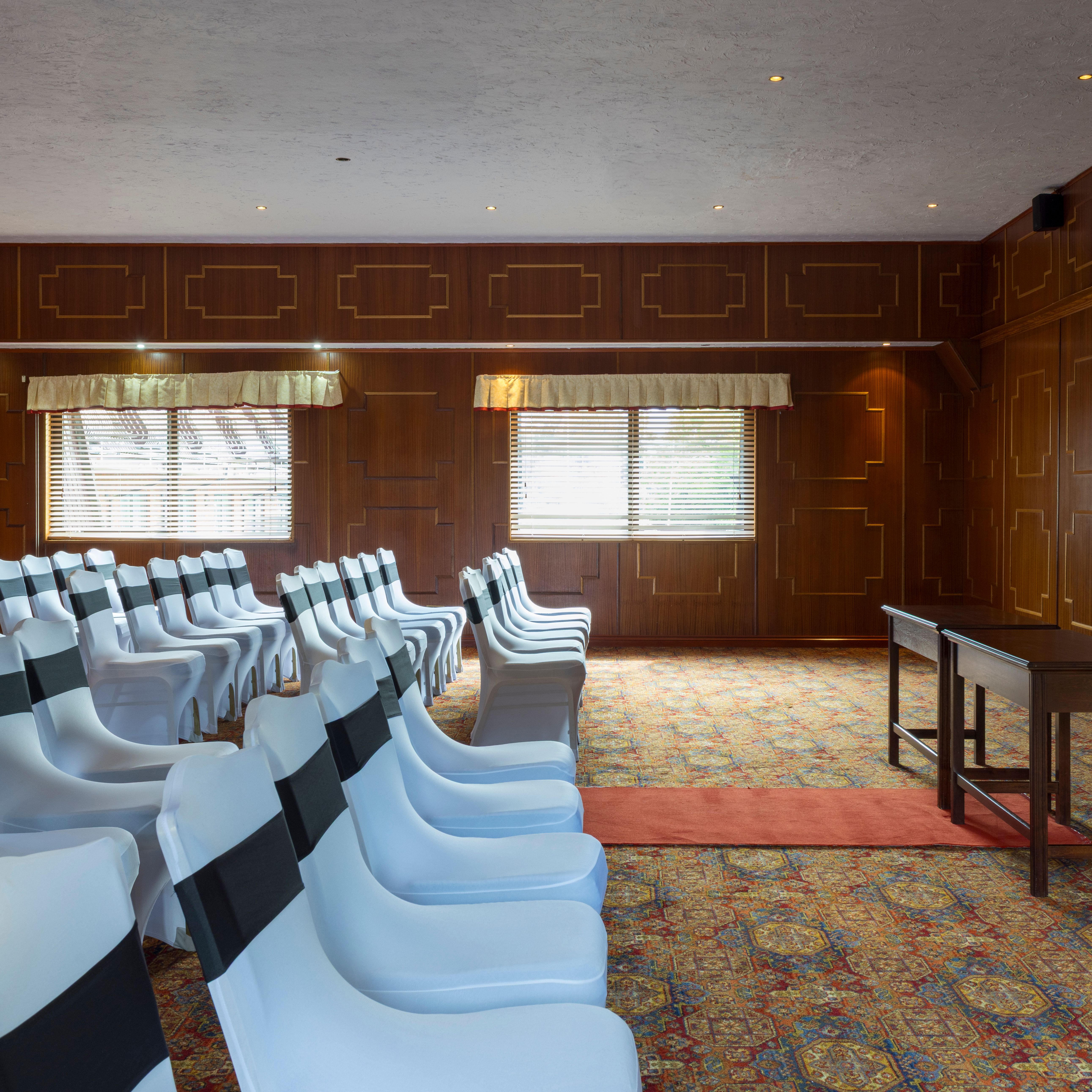 Conference room with white covered chairs and wooden paneling