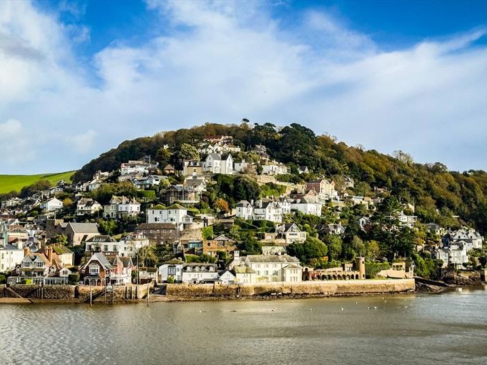 Hillside village of Kingswear overlooking the River Dart under a blue sky