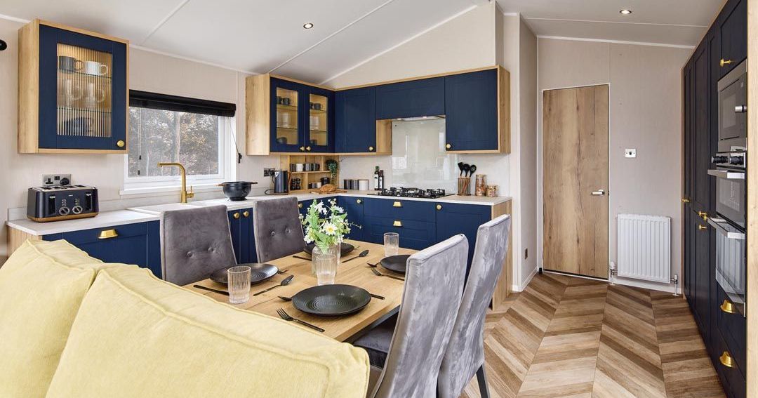 Modern kitchen diner with navy cabinets, wooden worktops and dining table set for four