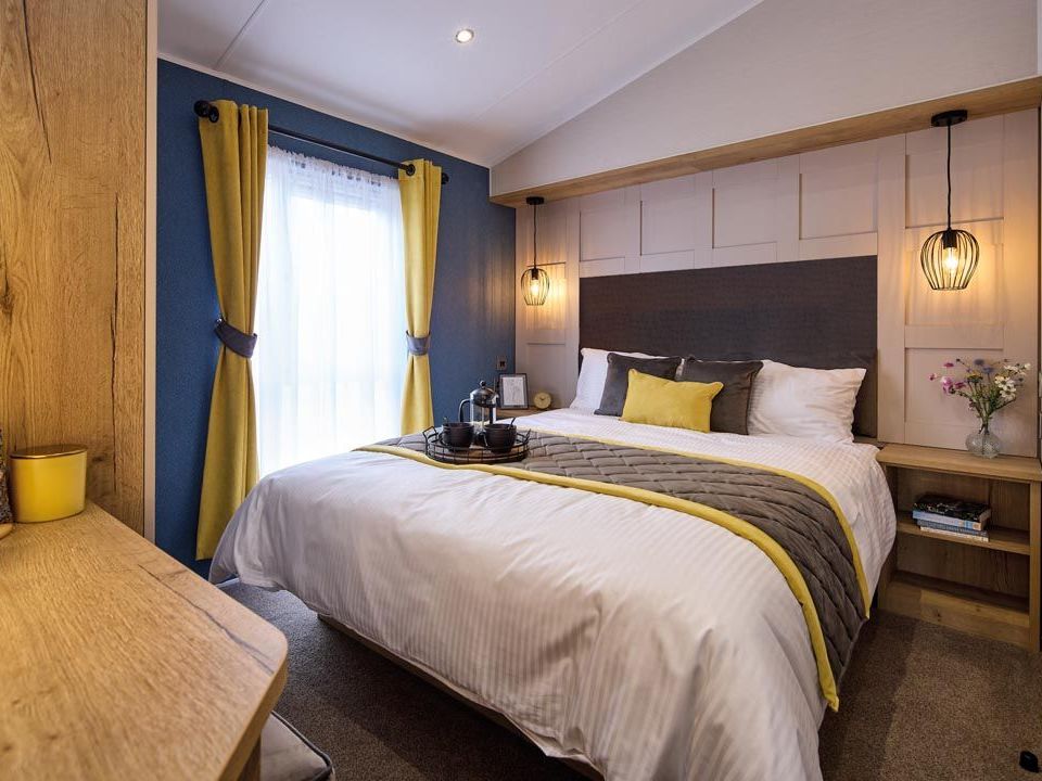 Modern bedroom with double bed, mustard curtains, and pendant lights