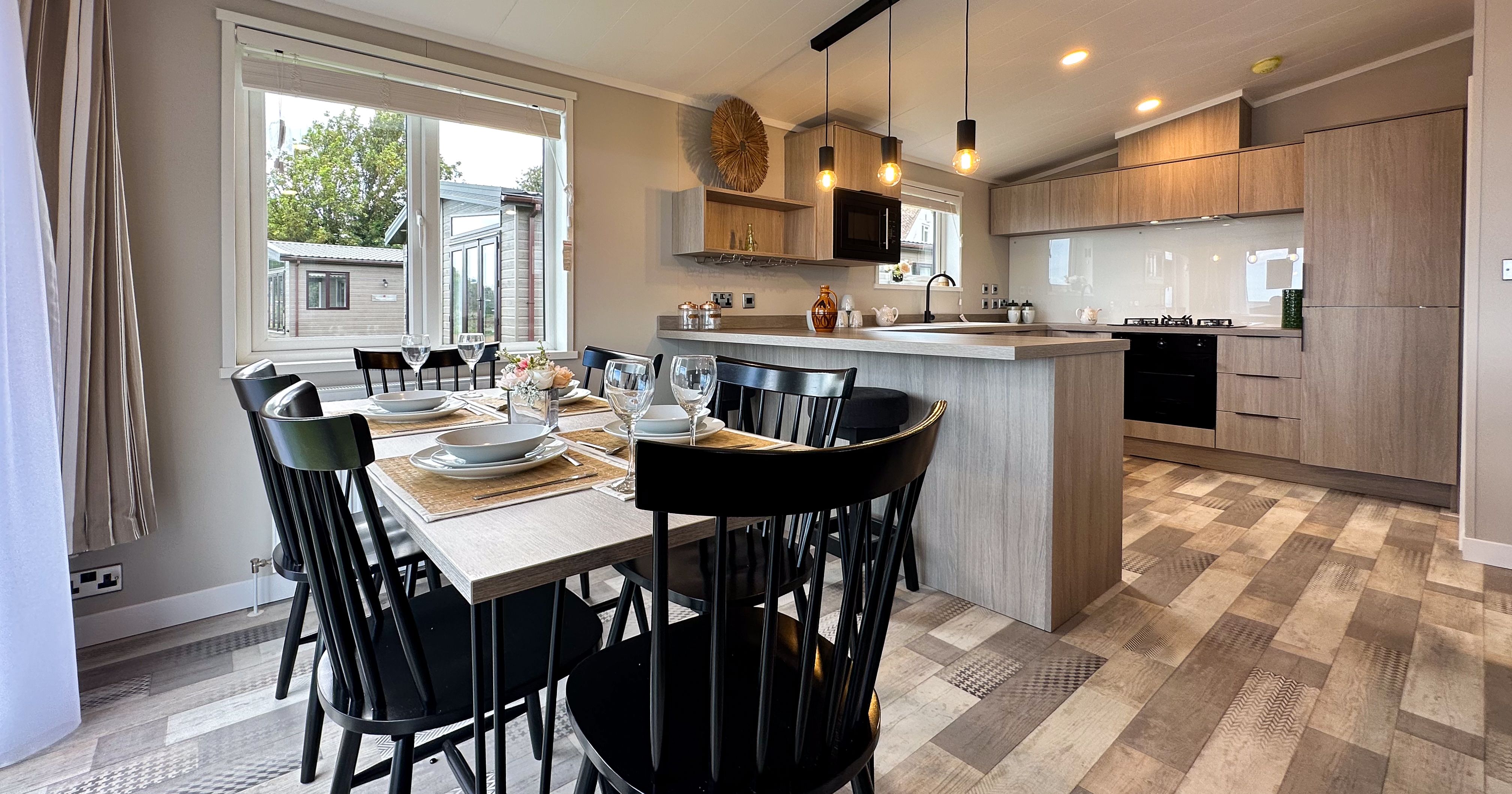 Modern open-plan kitchen and dining area with set table and pendant lights