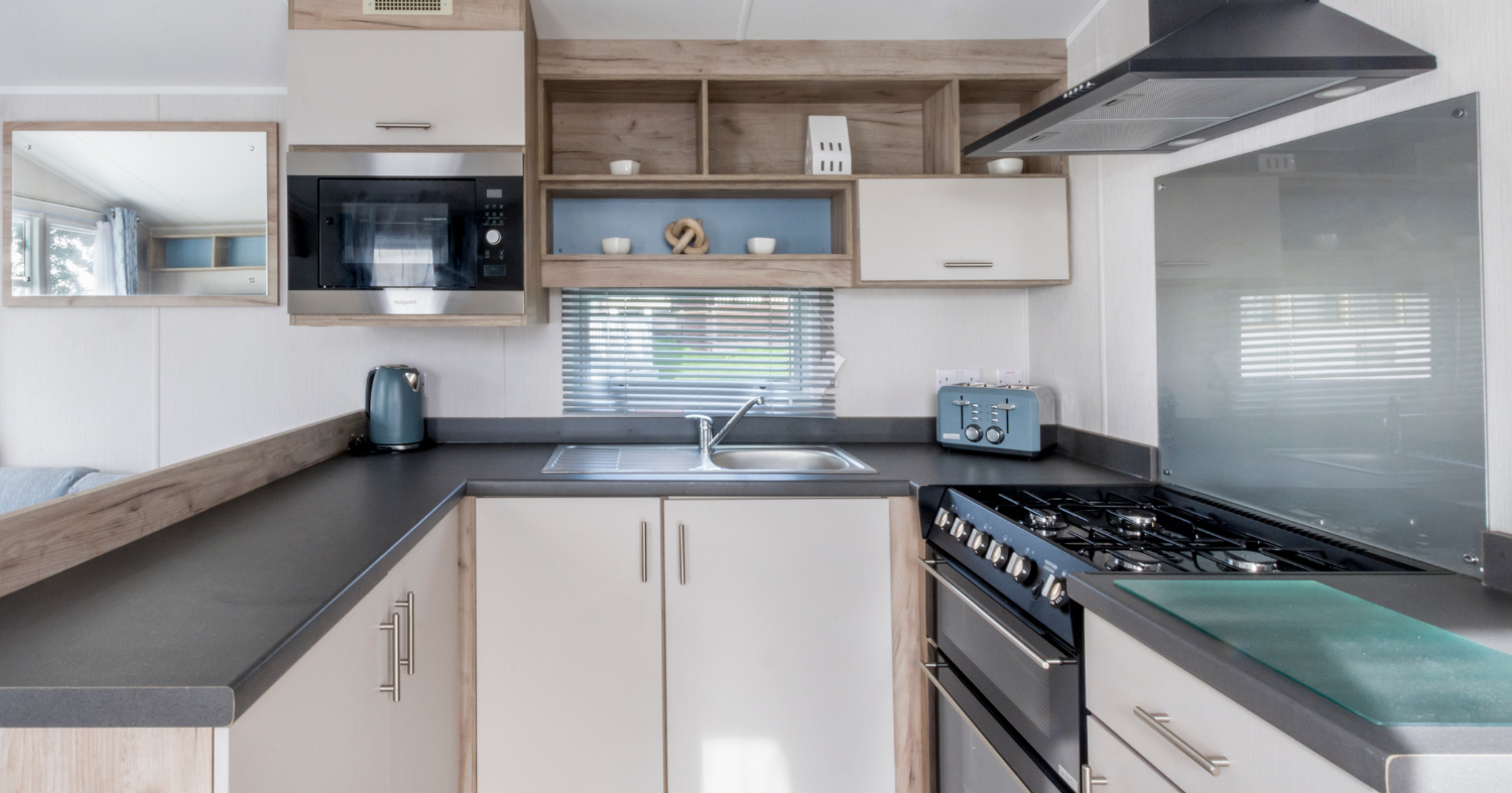 Modern compact kitchen with gas hob, extractor hood and corner sink