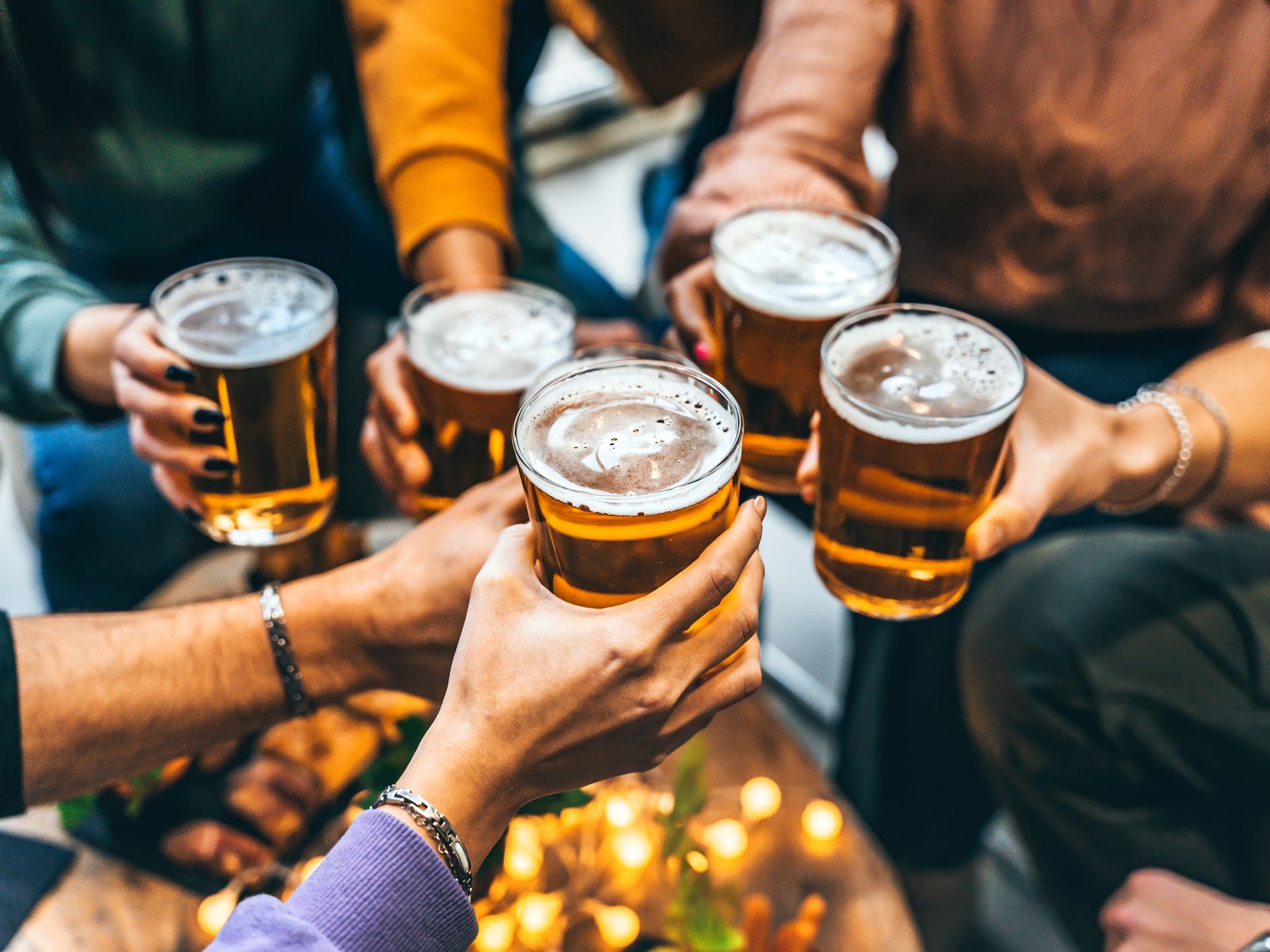 Friends holding pints of beer together in a toast