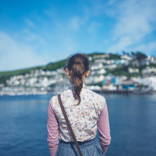 Woman in a floral vest admiring the view of Dartmouth across the water.