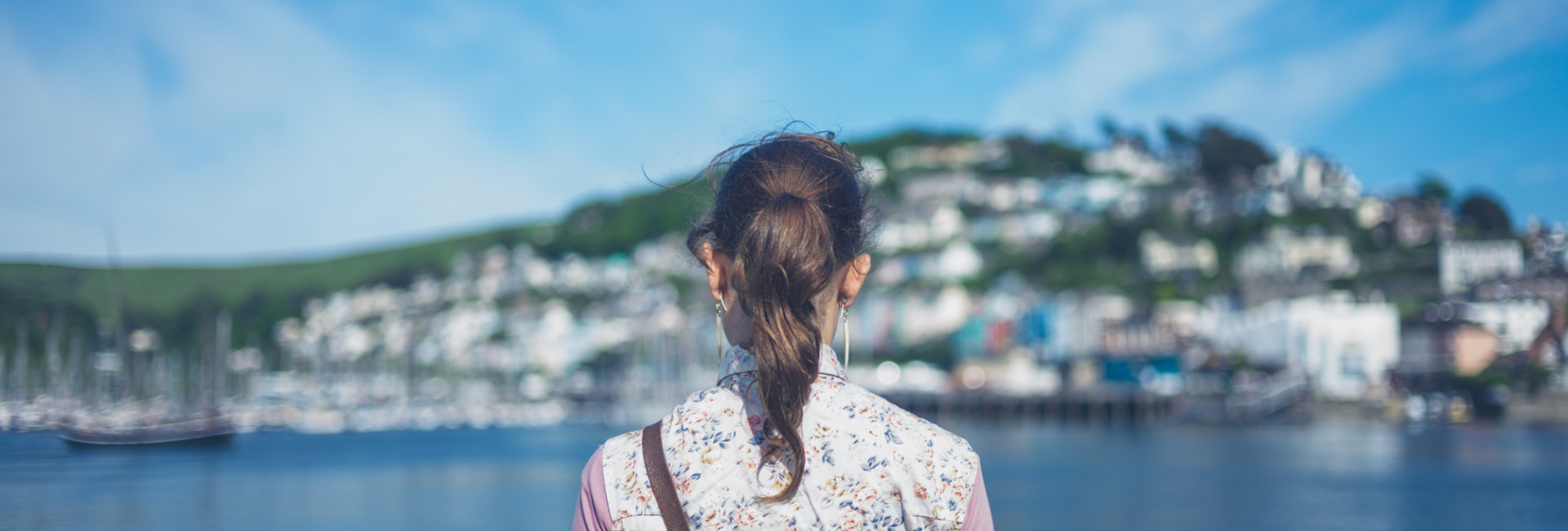 Woman in a floral vest admiring the view of Dartmouth across the water.