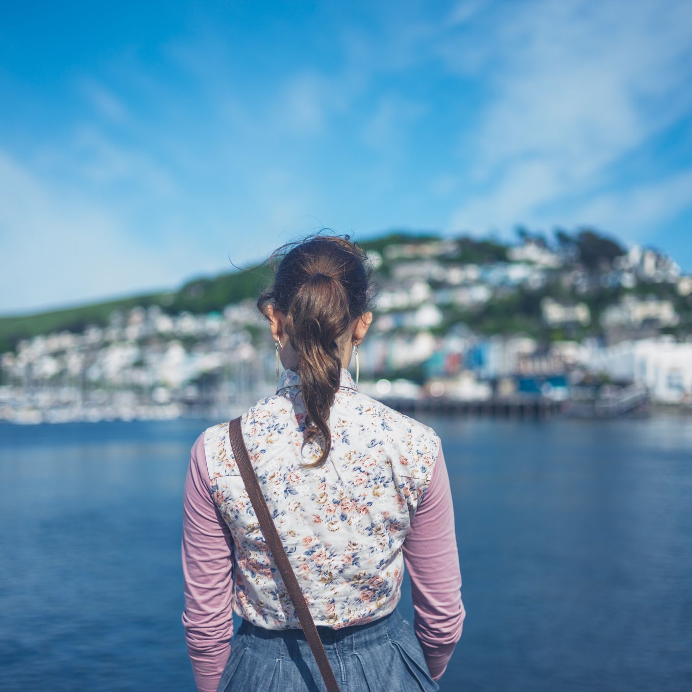 Woman in a floral vest admiring the view of Dartmouth across the water.