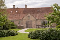 Stone house with red tiled roof and garden