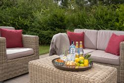 Outdoor patio furniture with drinks and snacks on a table