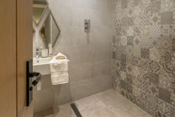 Modern bathroom with patterned tiles and open shower