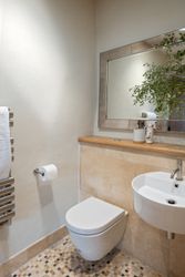 Modern minimalist bathroom with floating toilet and wall-mounted sink.