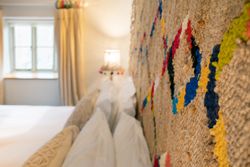 Cozy bedroom with textured, woven headboard and colorful accents