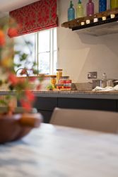 Modern kitchen countertop with jars of pasta sauce, spaghetti, and vegetables near a window
