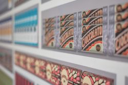 Closeup of a display of vintage product packaging designs on a wall, including packages labeled 'CIOCCOLATO'.