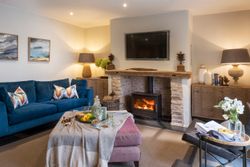 Cozy living room with blue sofa, wood-burning fireplace, and stylish decor