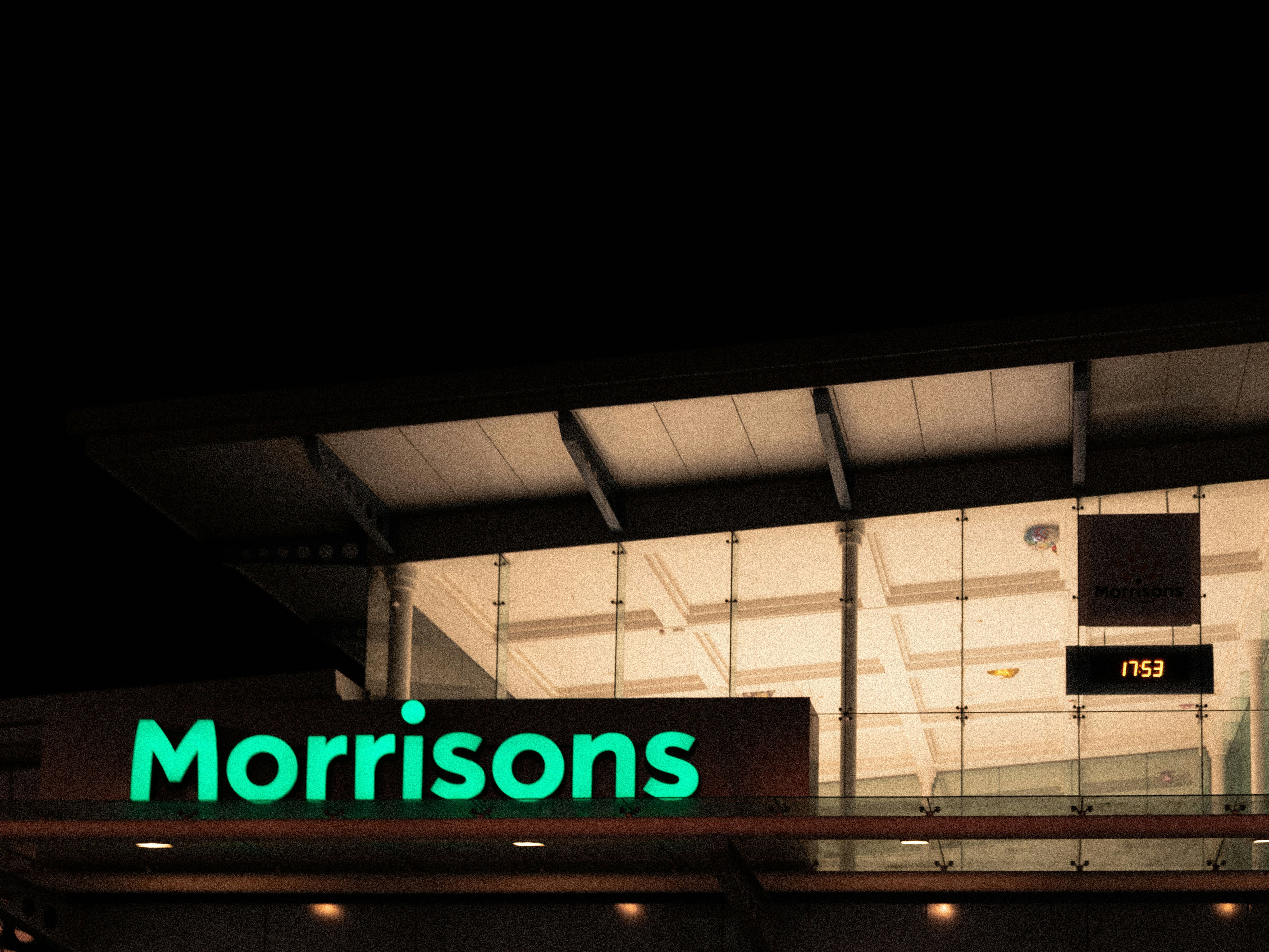 Morrisons supermarket entrance illuminated at night