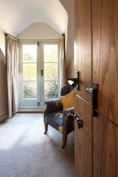 Cozy room with armchair by French doors and wooden furniture