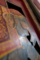 Close-up of a painted wooden elephant on a decorative surface