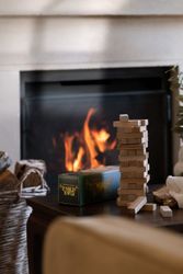 Tumblin Tower game set and stacked wooden blocks on a table in front of a fireplace