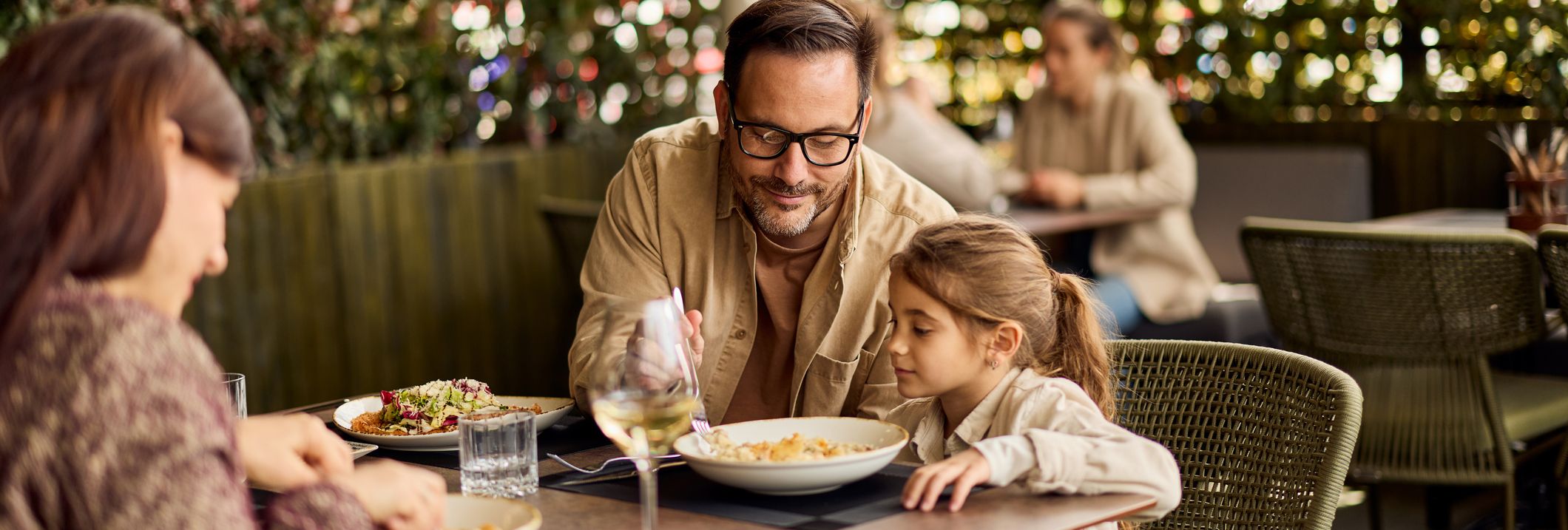 Family enjoying a meal together at an outdoor restaurant