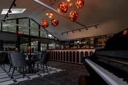 Modern bar area with elegant lighting, piano, and seating