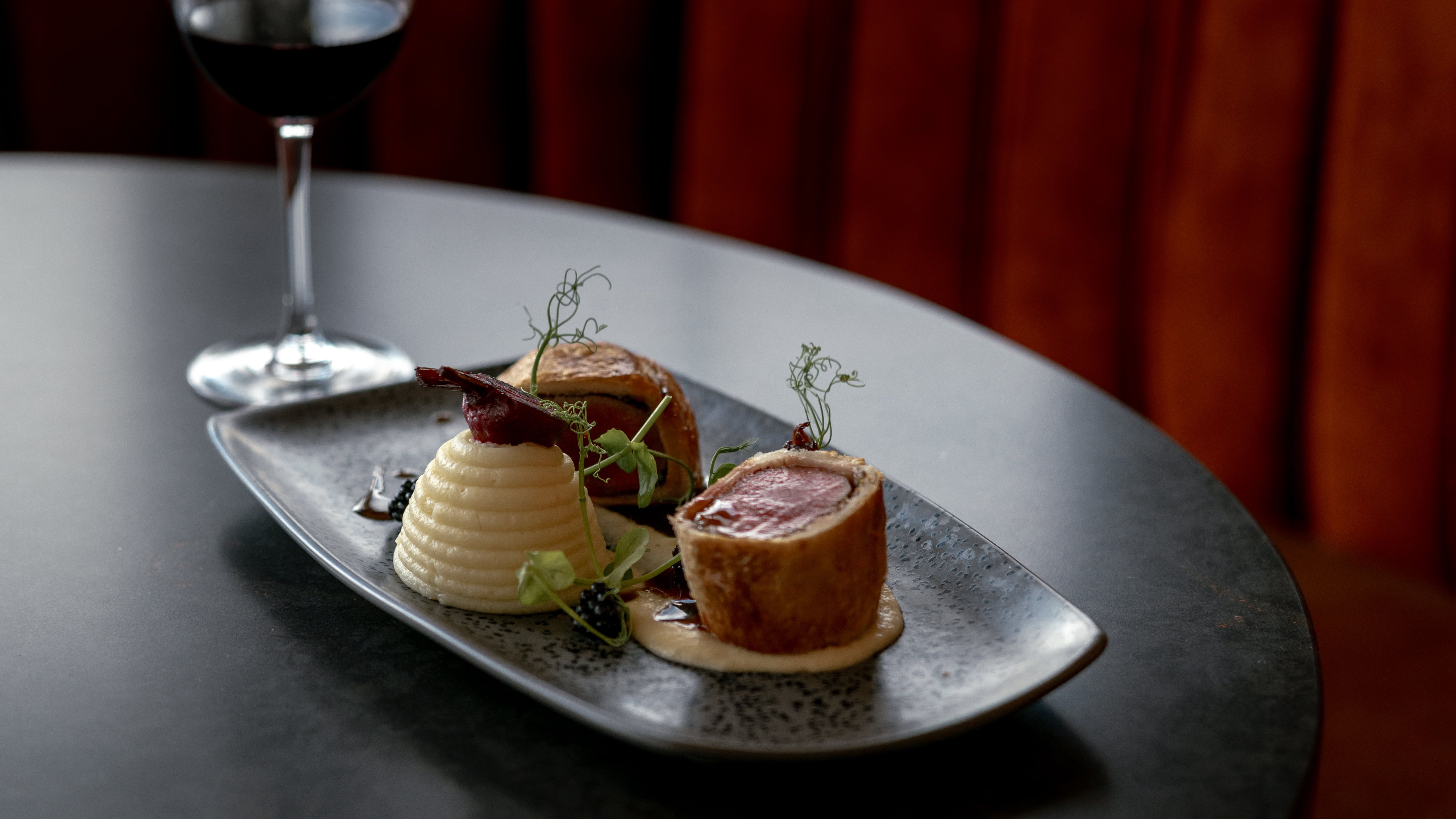 Gourmet plated meal with a glass of red wine