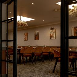 Elegant private dining room with modern decor, large table, and warm lighting