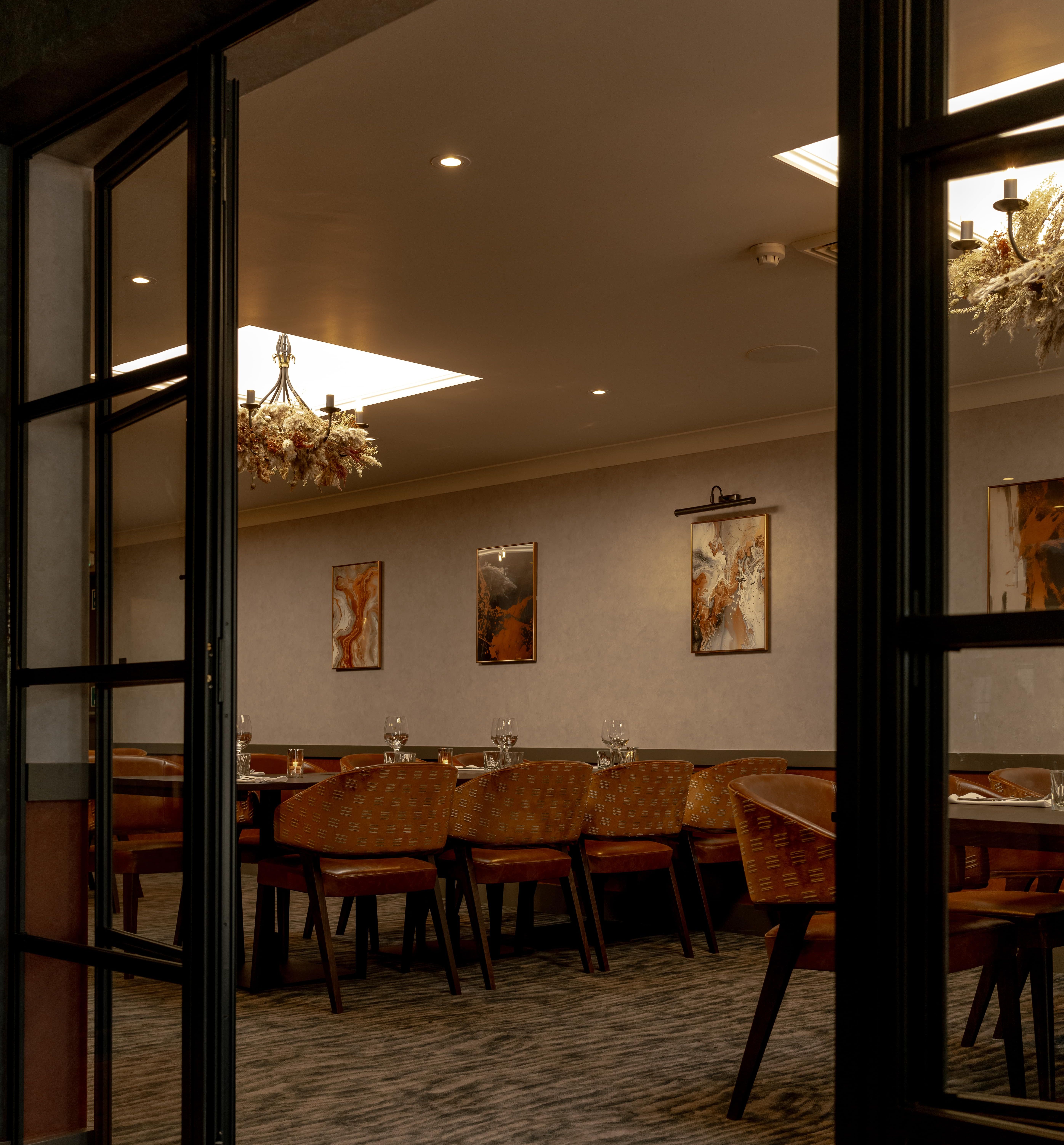 Elegant private dining room with modern decor, large table, and warm lighting