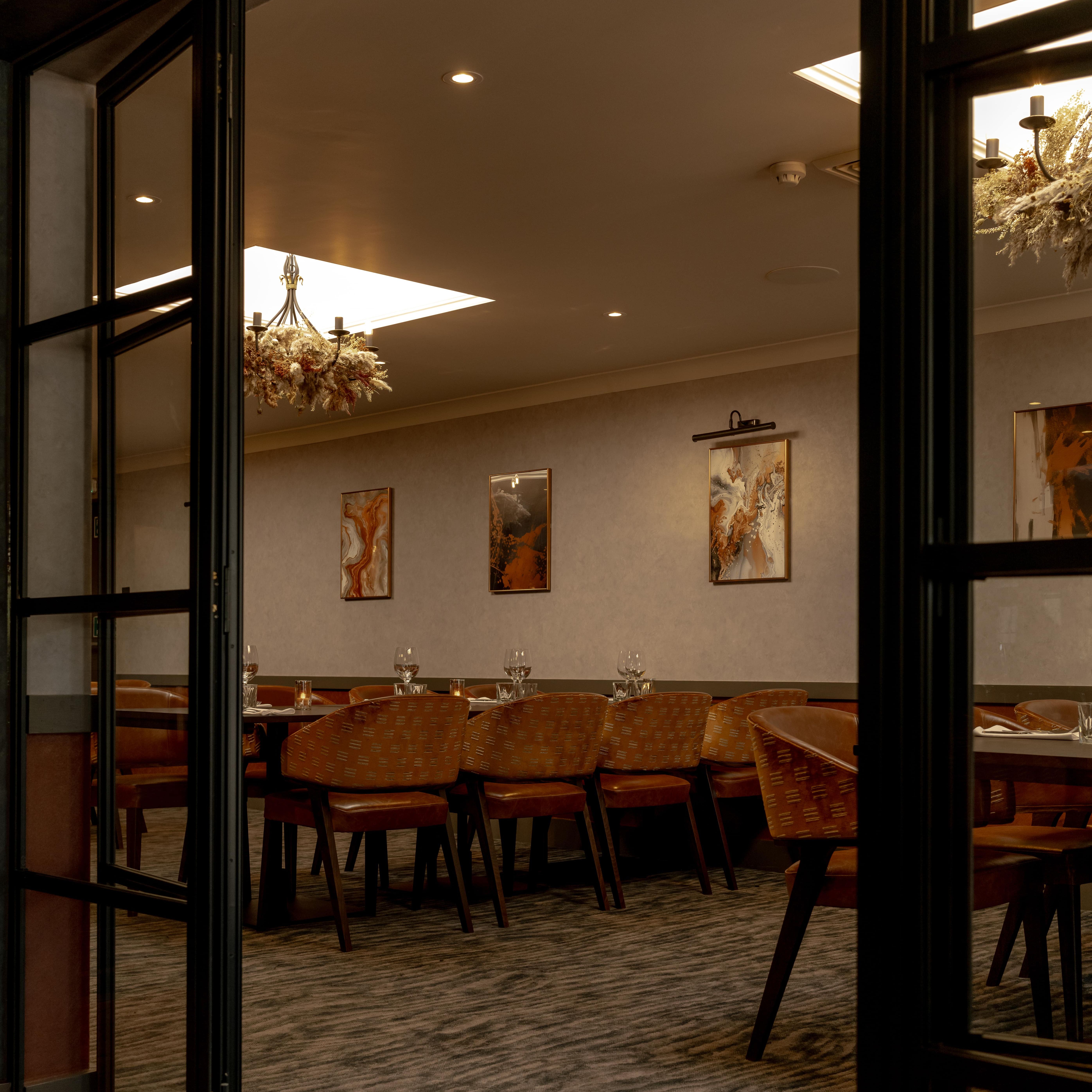 Elegant private dining room with modern decor, large table, and warm lighting