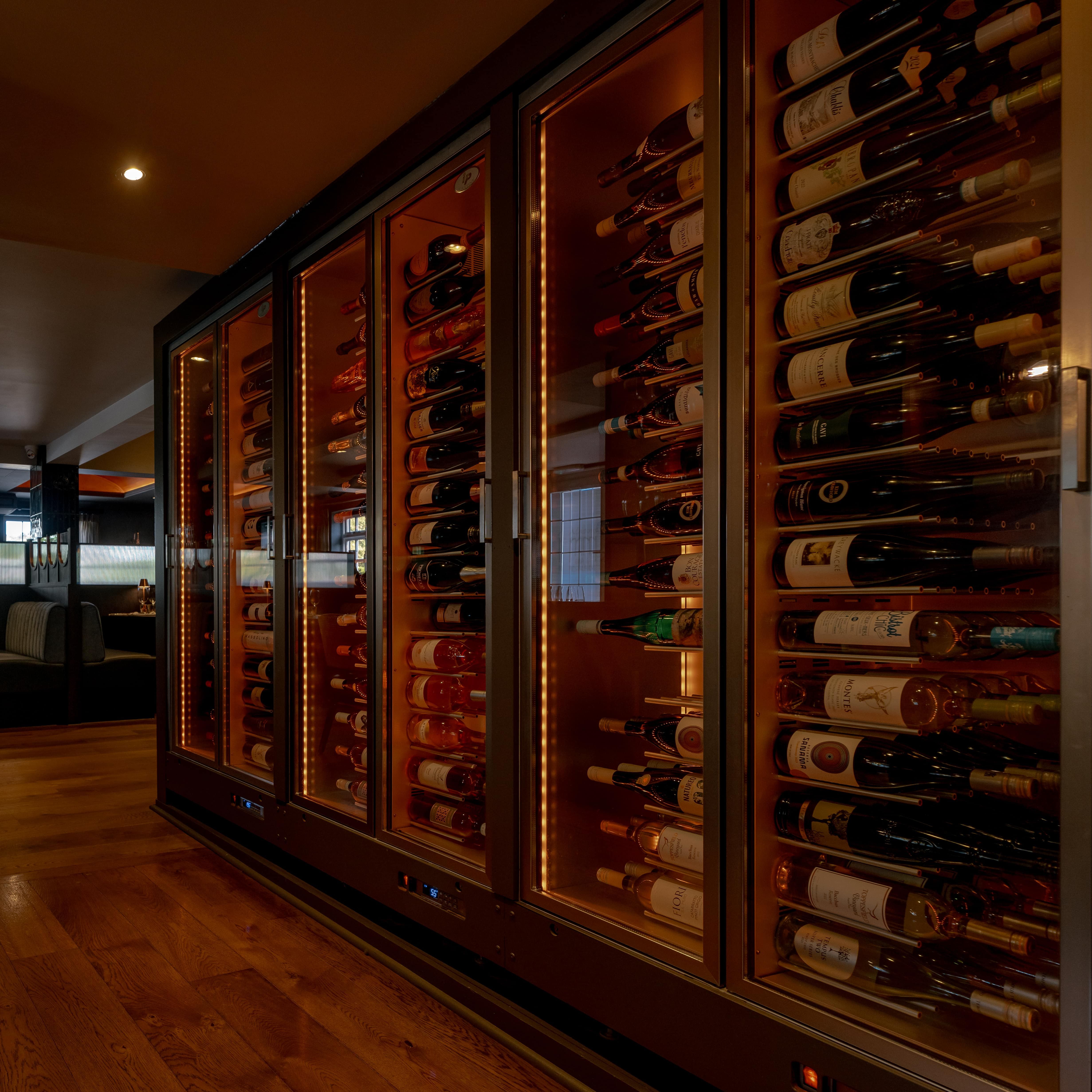 Modern restaurant interior with a glass wine cellar and cozy dining booths