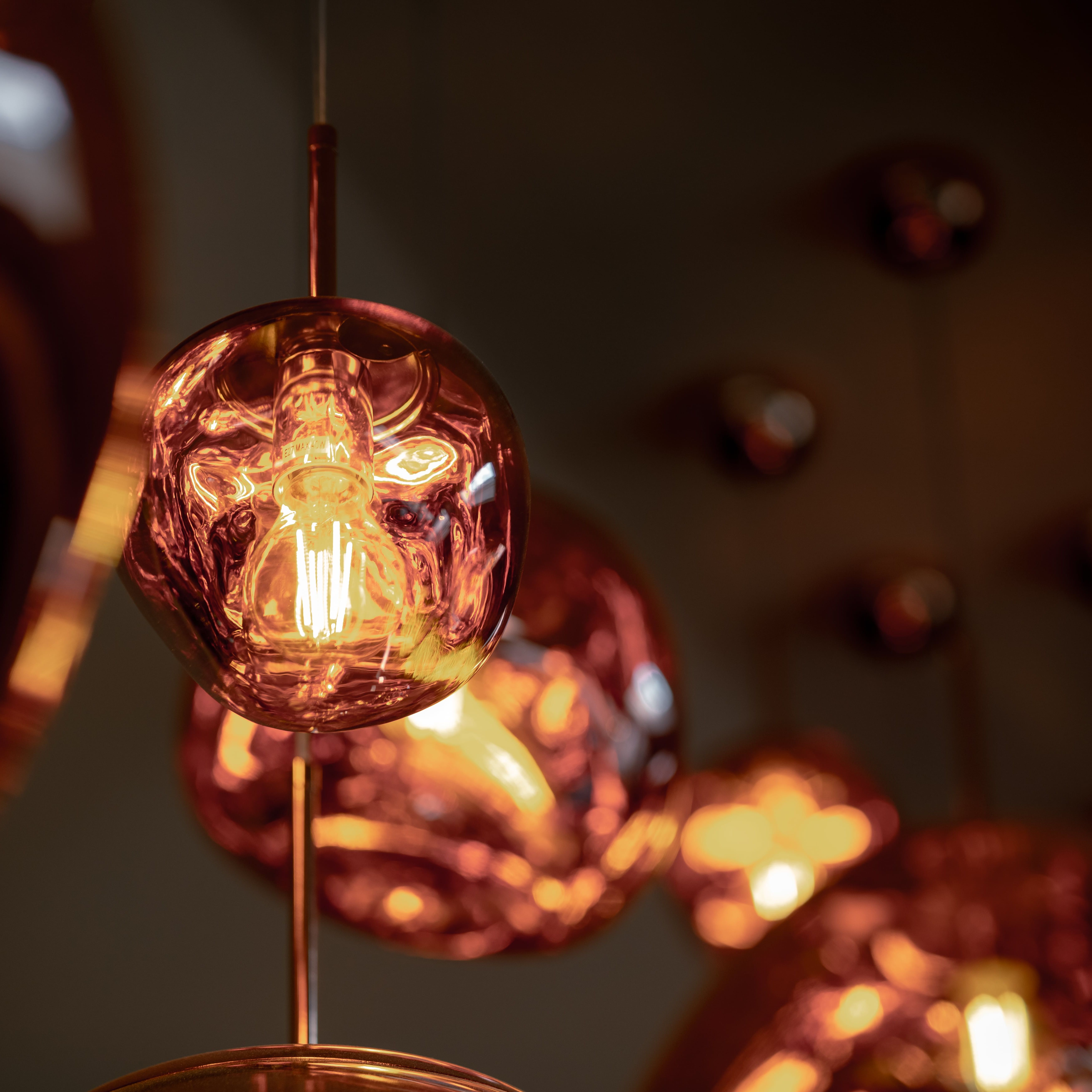 Close-up of a modern copper pendant light with an exposed filament bulb