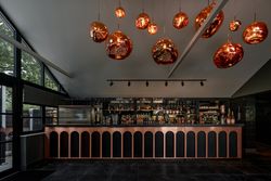 Modern bar area with unique copper pendant lights hanging from the ceiling above a stylish bar counter.