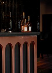 Modern bar counter with three bottles of rosé wine and stylish dark decor