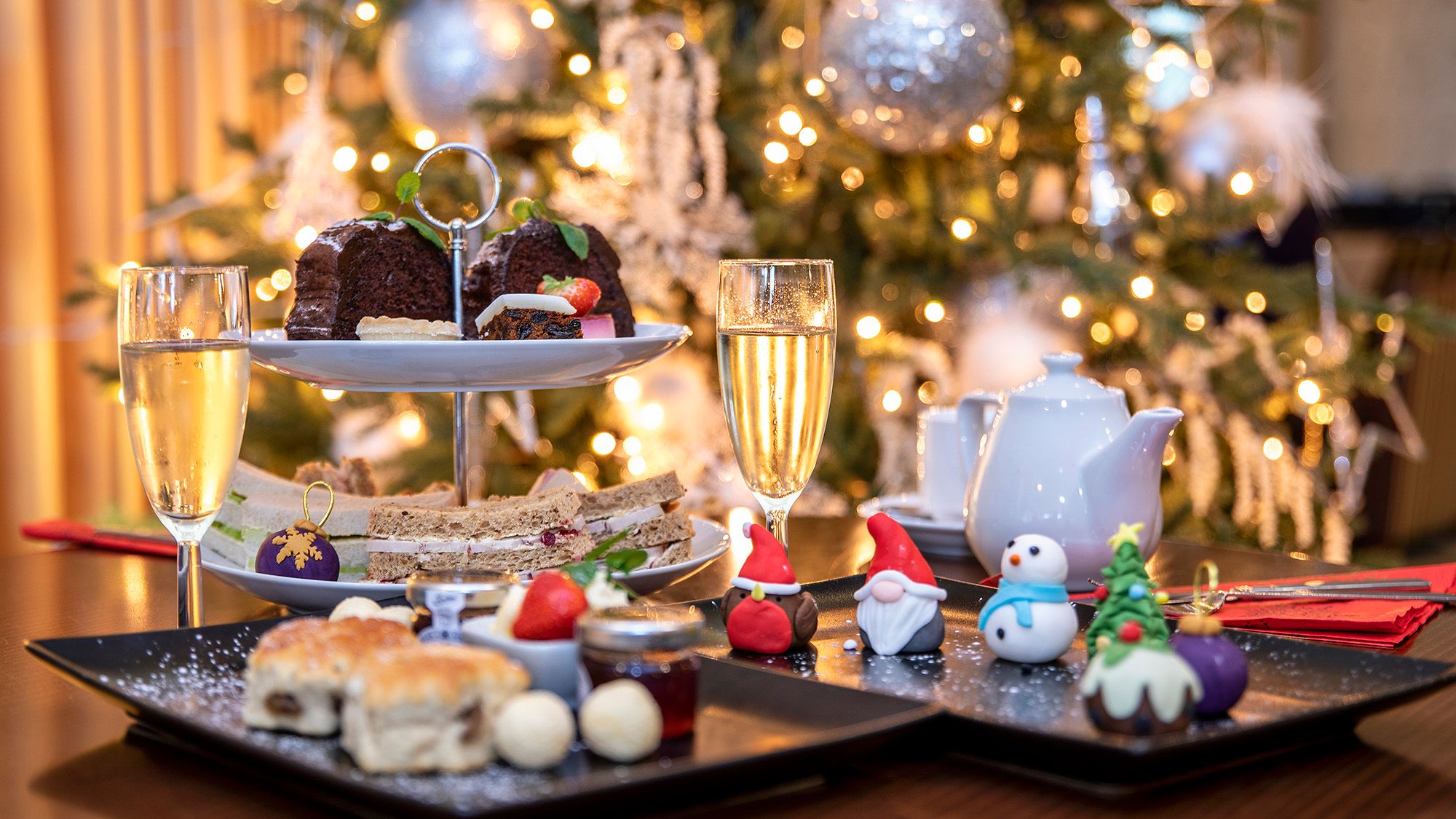Festive afternoon tea with champagne by Christmas tree
