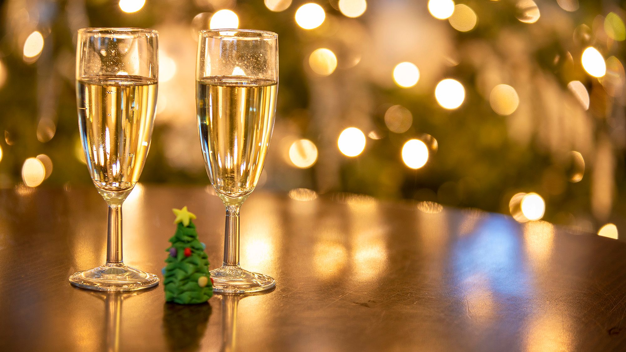 Two glasses of champagne by Christmas tree