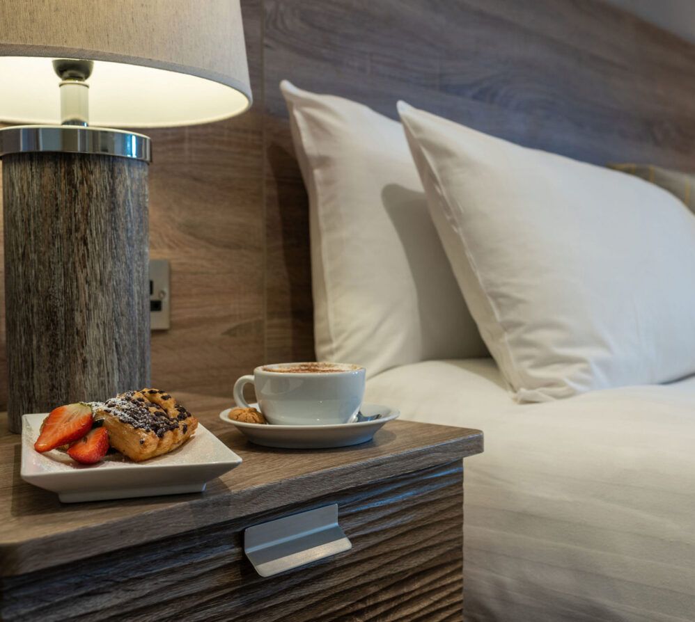 Pastry and coffee on bedside table