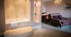 magnificent hotel suite with standalone bath and crystal chandelier