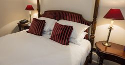 four poster hotel bed with luxury cushions and bedding