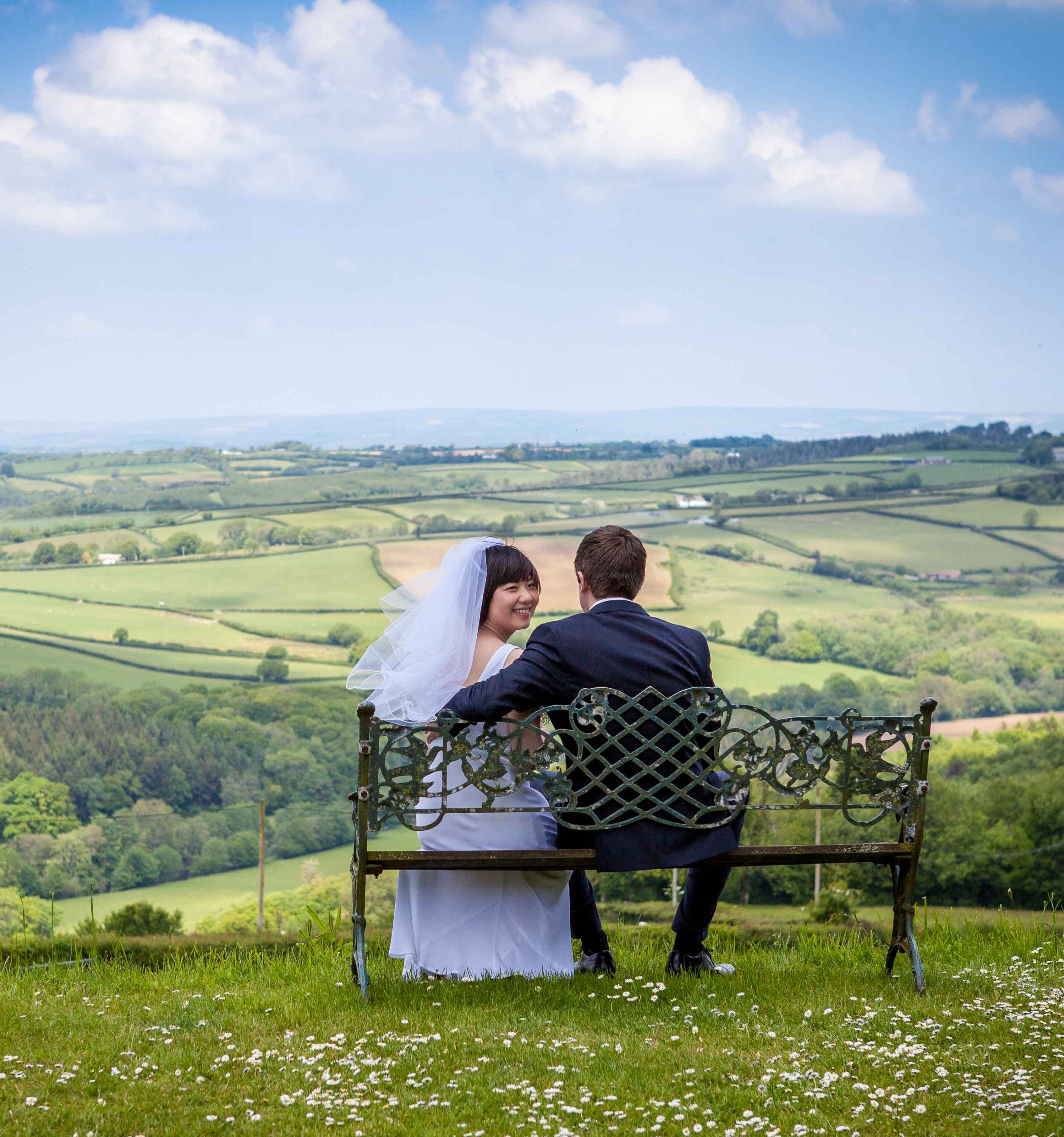 Couple sitting on a bench overlooking the Devon countryside