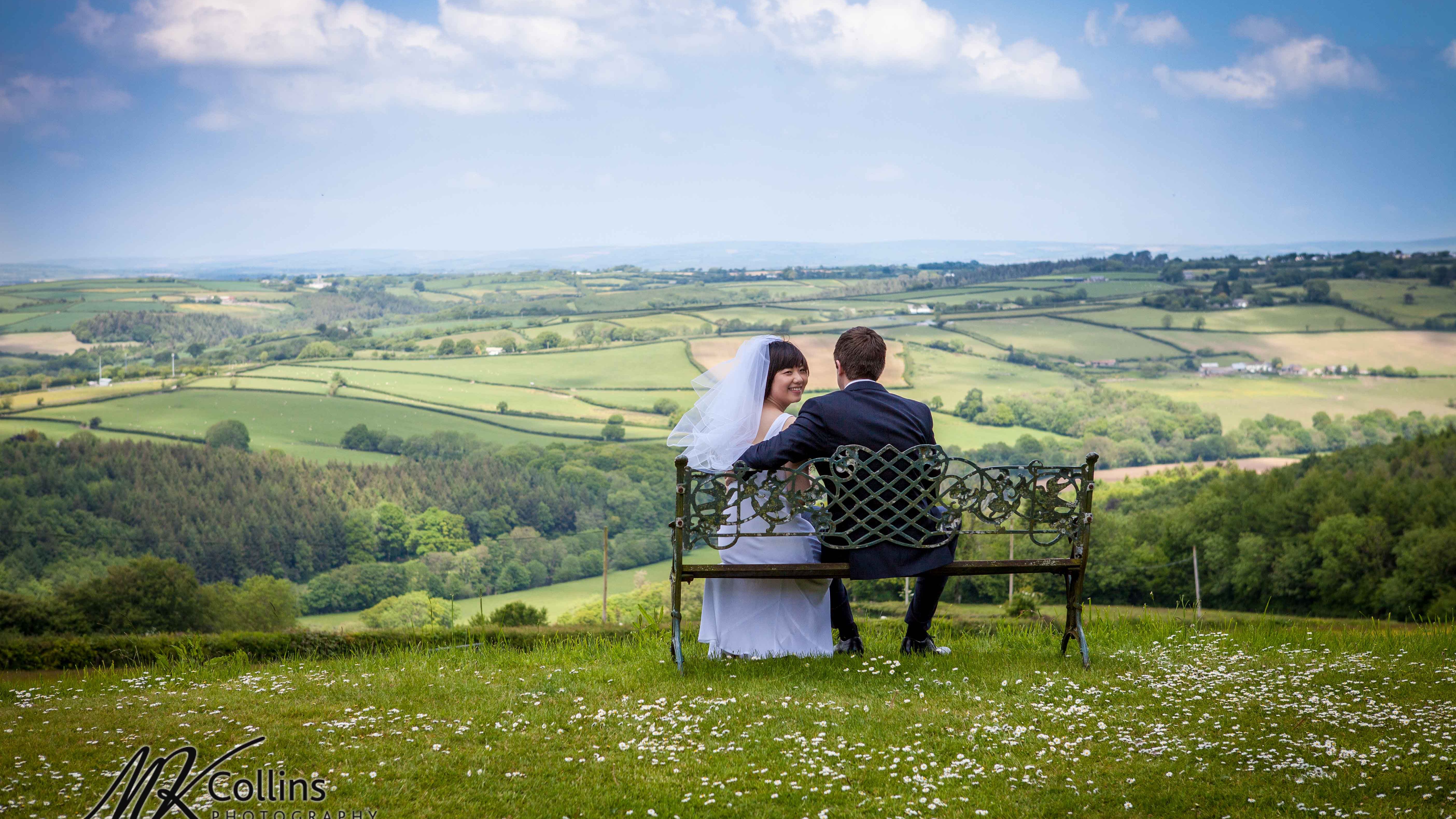 Couple sitting on a bench overlooking the Devon countryside