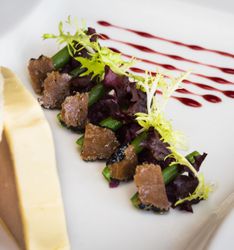 Elegant dish of fresh salad with sliced truffles and green beans, garnished with mixed greens