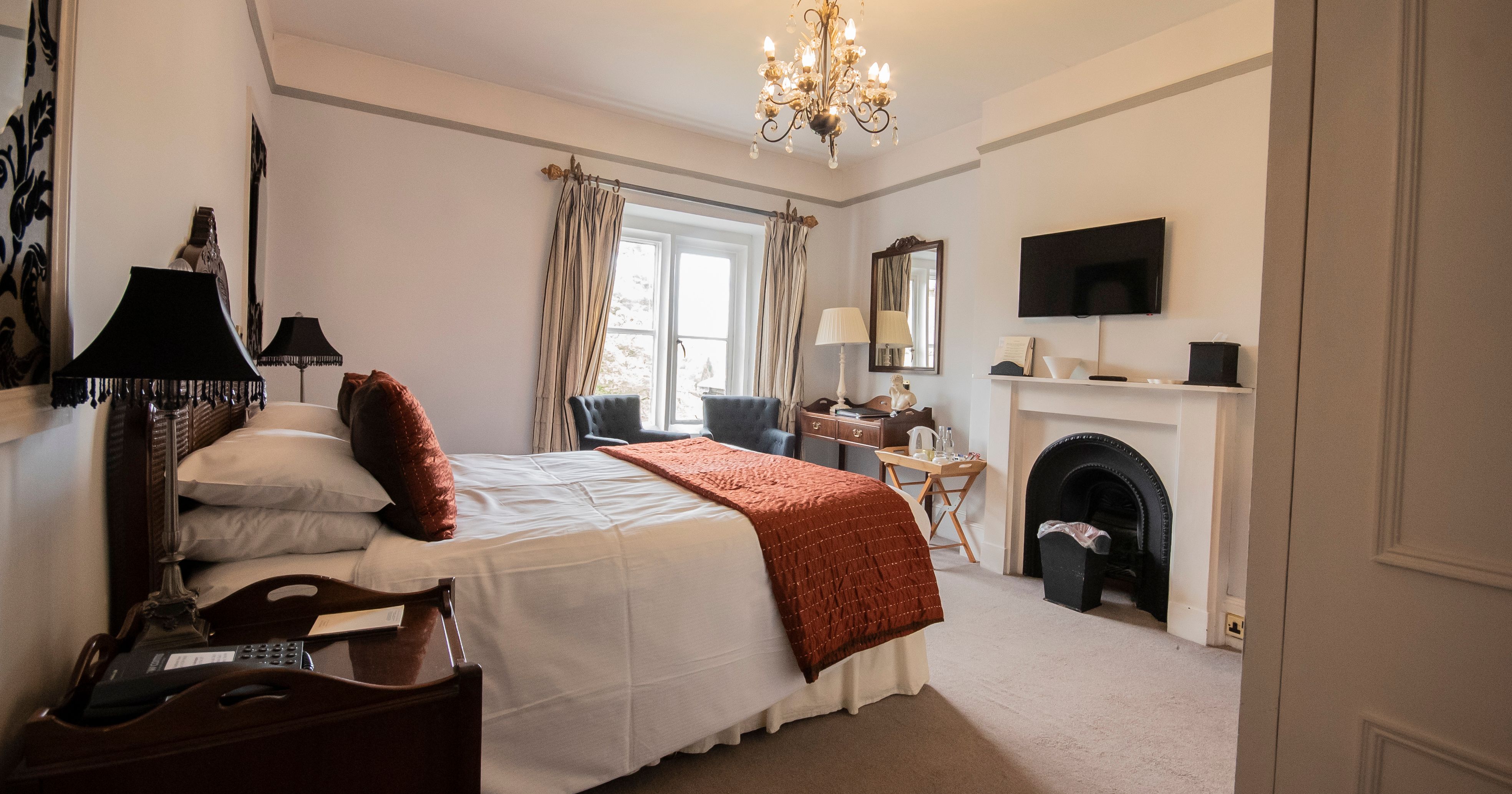 Bedroom with statement fireplace and chandelier