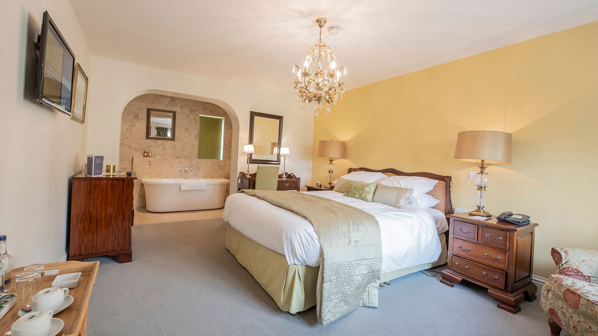hotel room with crystal chandelier and free-standing bath