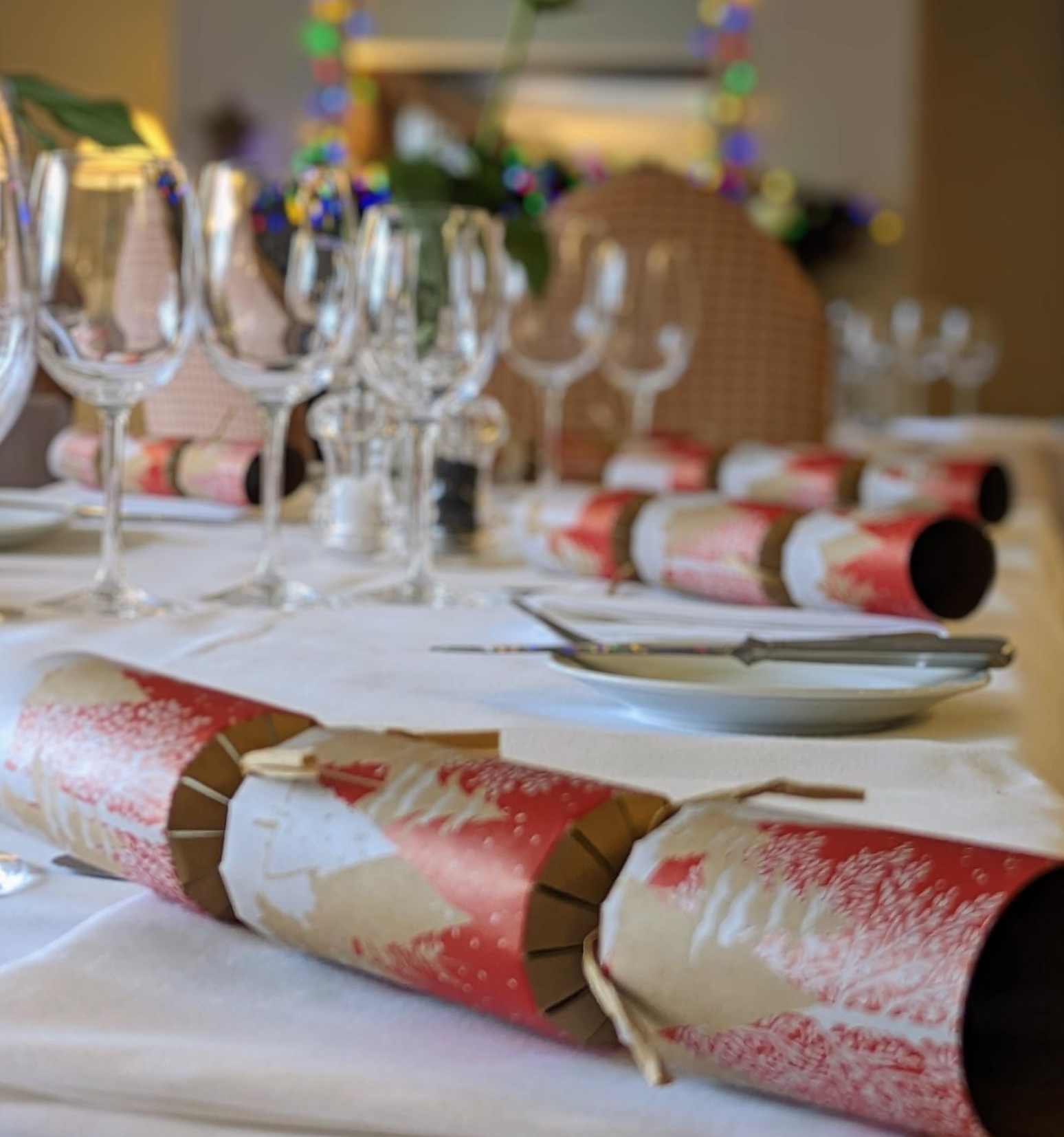 Festive table setting with Christmas crackers and glassware